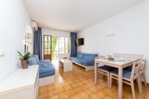 een woonkamer met een blauwe bank en een tafel bij Apartamentos Casa Vida in Santa Ponsa