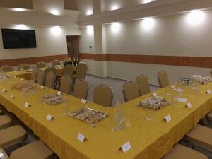a long table in a room with chairs and glasses at Viešbutis Kelyje in Utena