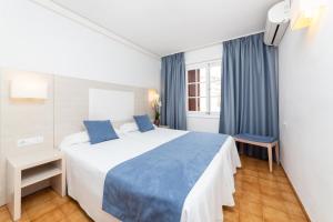 een hotelkamer met een groot bed met blauwe lakens bij Apartamentos Casa Vida in Santa Ponsa
