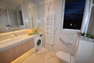 uma casa de banho com um lavatório e uma máquina de lavar roupa em Apartment Royal Residence em Sarajevo