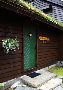 a green door of a house with a sign on it at Byrkjedalstunet Hotell in Byrkjedal