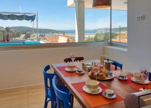 una mesa de comedor con sillas azules y una mesa con tazas en Villa en Pedracuca Nova, en Cabana de Bergantiños