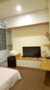 馬公市にあるFishmoon homestayのベッドルーム1室(ベッド1台、デスク、薄型テレビ付)