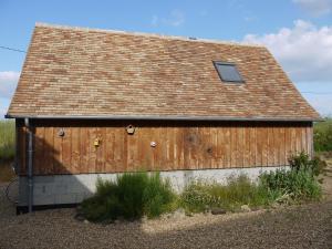 a wooden building with a brown roof at Maison proche circuit 24h du Mans in Louplande