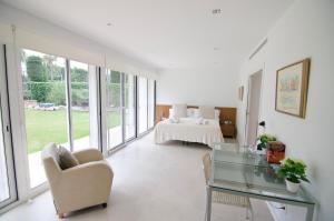 a living room with a glass table and a bed at Luxury Beach House in Sitges