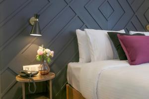 a bedroom with a bed and a table with a vase of flowers at The Roomy Hotel Şişli in Istanbul