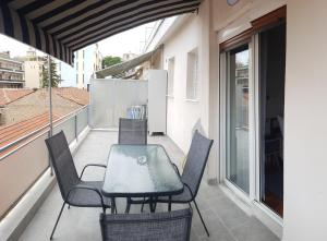 patio ze stołem i krzesłami na balkonie w obiekcie MAHE APARTMENT w mieście Wolos