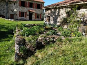 an old stone house with a garden in front of it at Les Fayettes in Montregard