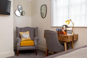 a bedroom with a desk and a chair and a bed at The Old Cock Inn in Harpenden