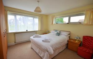 um quarto com uma cama e uma cadeira vermelha em Solent View em Seaview