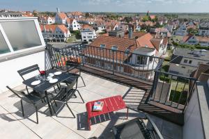 a balcony with a table and chairs on a roof at knokkeappart Penthouse 2-3 pers in Knokke-Heist
