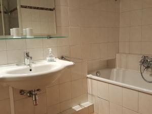 ein Badezimmer mit Waschbecken und Badewanne in der Unterkunft Sylter Besserburg App. 2P in Westerland