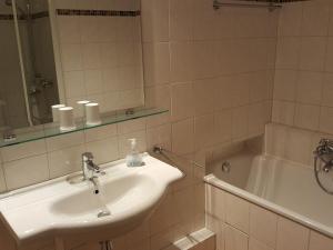 ein Badezimmer mit Waschbecken und Badewanne in der Unterkunft Sylter Besserburg App. 2P in Westerland