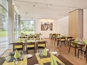 a restaurant with tables and chairs and a large window at Hotel Tödi in Linthal