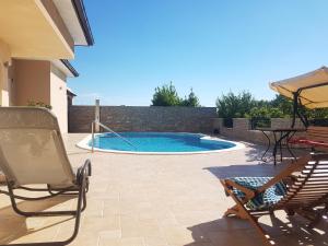 a patio with a swimming pool and a table and chairs at Villa Vacanza in Međugorje