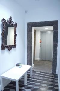 a mirror and a white bench in a hallway at Heritage Apartments in Funchal