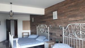 a bedroom with two beds and a wooden wall at Motel Traffic in Linteşti