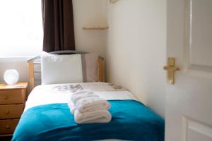 a bedroom with a bed with towels on it at Apartment 2, Pheonix Flats in Portree