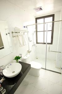 y baño con lavabo, aseo y ducha. en Thăng Long Hotel II en Ha Long