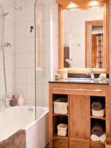 a bathroom with a sink and a tub and a mirror at Savoy Morzine in Morzine