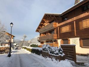 a building with snow on the ground next to a street at Savoy Morzine in Morzine