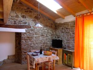 a dining room with a table and a stone wall at Casa delle Stelle in Castelmezzano