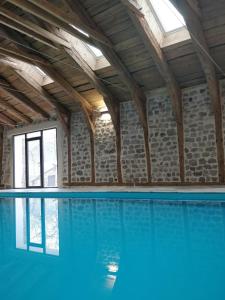 a swimming pool with blue water in a building at Les Fayettes in Montregard