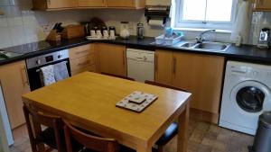 a kitchen with a wooden table and a sink at Apartment 4 Pheonix Flats in Portree