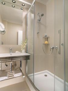a bathroom with a shower and a sink at Blazer Suites Hotel in Athens