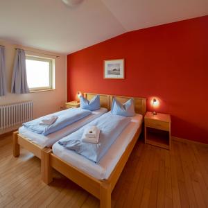 um quarto com uma cama grande e uma parede vermelha em Biohotel Stiftsgut Wilhelmsglücksbrunn em Creuzburg