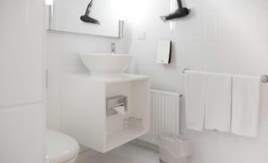 a white bathroom with a sink and a toilet at Hotel Deutsches Theater in Munich