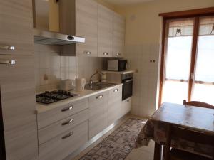 cocina con fogones, fregadero y mesa en Maison Buthier, en Aosta