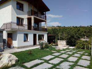 a white house with a balcony and a yard at Casa Del Grey in Balchik