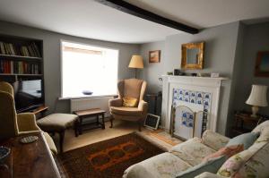 a living room with a couch and a fireplace at Grove Cottage in Yarmouth