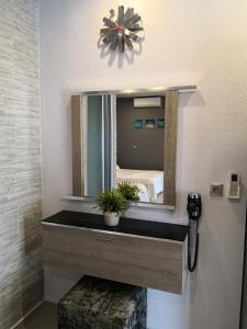 a bathroom with a sink and a mirror at Aimilias Family Apartments in Nea Vrasna +55 photos