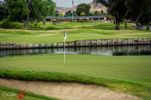 un campo de golf con una bandera en un green en Carlton Oaks Lodge, Ascend Hotel Collection en Santee