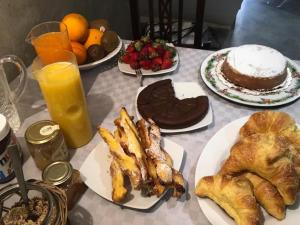 una mesa con platos de repostería, pasteles y zumo de naranja en Kurò, en Palermo