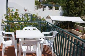 - Balcón con mesa blanca y sillas en Case Vacanza La Serricella, en Santa Cesarea Terme