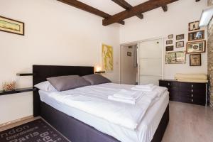 een slaapkamer met een groot bed met witte lakens bij Molnar Resort Villa Mimoza & Apartment Nea in Brzac