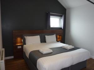 a bedroom with a large bed with two towels on it at Oakwood Farm Mews Chester in Chester