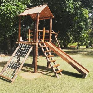 a wooden playground with a slide in a park at Hospedagem Fazenda Nova América in Brotas