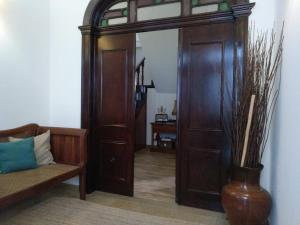 salon z dużymi drewnianymi drzwiami i kanapą w obiekcie Blue Castle House w mieście Gouveia