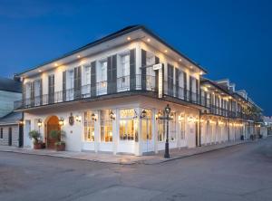 a large white building with a balcony on a street at Chateau Hotel in New Orleans