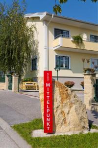 a red sign in front of a large rock at Appartementhaus Das Mittelpunkt in Mörbisch am See