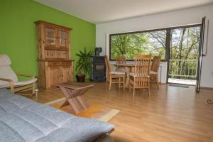 1 dormitorio con paredes verdes, mesa y sillas en Haus am Dreifelder Weiher, en Dreifelden