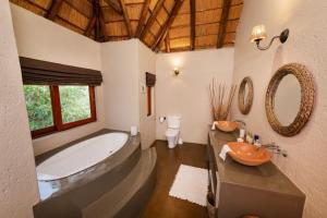 a bathroom with a large tub and a sink at Parsons House in Hoedspruit +46 photos
