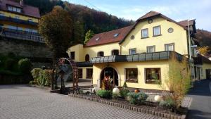 ein großes gelbes Gebäude an der Straßenseite in der Unterkunft Gasthof Hotel Schwarzes Roß in Bad Berneck im Fichtelgebirge