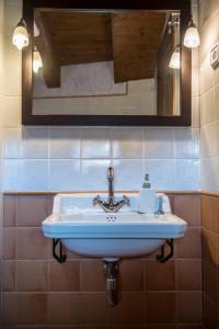 lavabo blanco en el baño con espejo en CASA BERNAT, en Aren