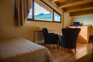 1 Schlafzimmer mit einem Bett, 2 Stühlen und einem Fenster in der Unterkunft CASA BERNAT in Aren