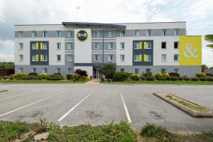 un edificio con un estacionamiento delante de él en B&B HOTEL Evreux, en Évreux